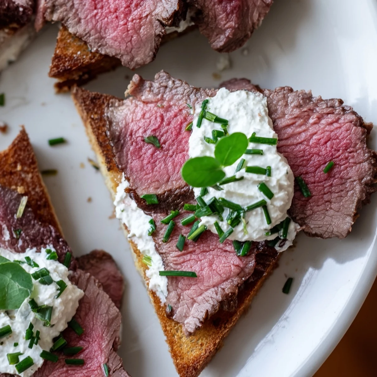 Freshly seared beef sits atop buttery Beef Toast Points, ready to be served with a tangy horseradish cream.