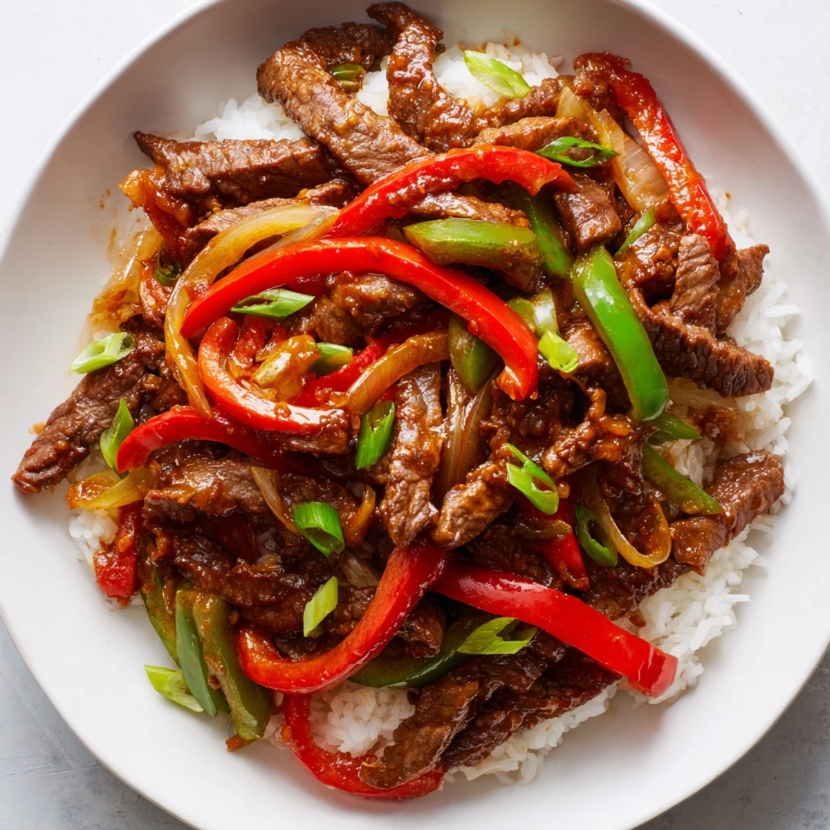 Sizzling pan of Spicy Stir Fry Beef with a rich chili garlic sauce, mixed with colorful vegetables for a quick and flavorful weeknight dinner.