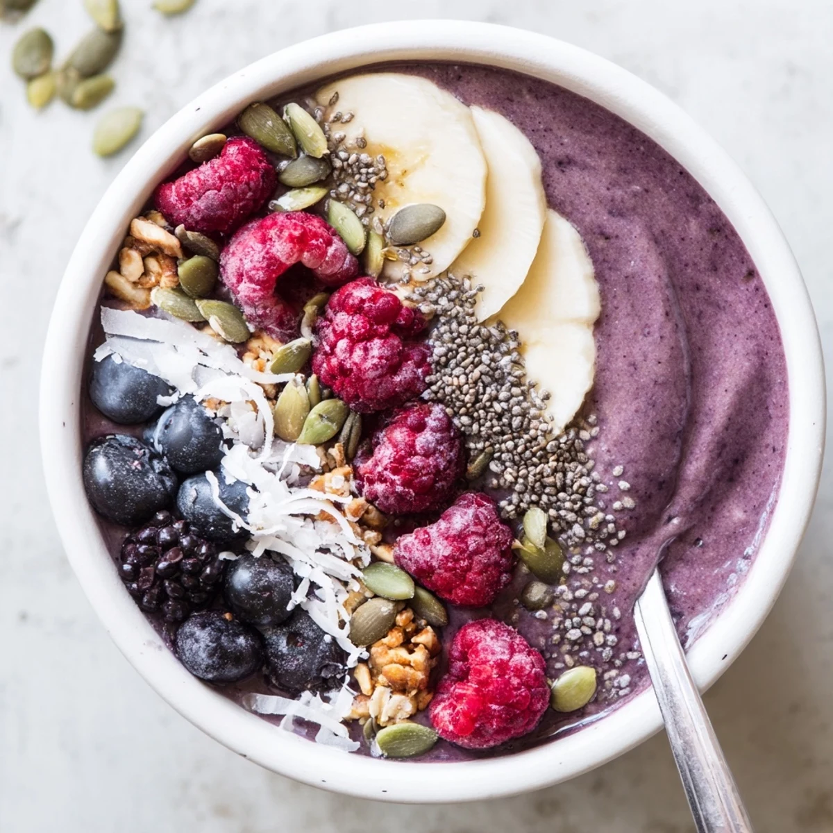 Two bowls of Winter Berry Smoothie Bowl with vibrant berries, creamy yogurt base, and seed toppings.