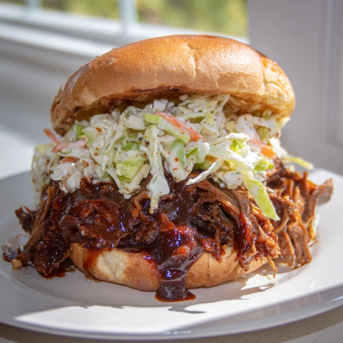 Homemade slow cooker beef sandwiches topped with fresh coleslaw and drizzle.