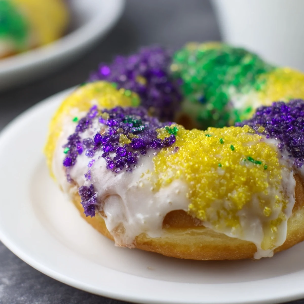 Warm, fluffy Mardi Gras Donuts ready to be enjoyed with a steaming cup of café au lait.
