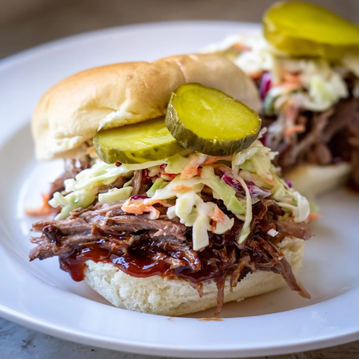Tender, smoky beef brisket piled on soft slider buns, topped with creamy coleslaw and crunchy dill pickles for a hearty meal.