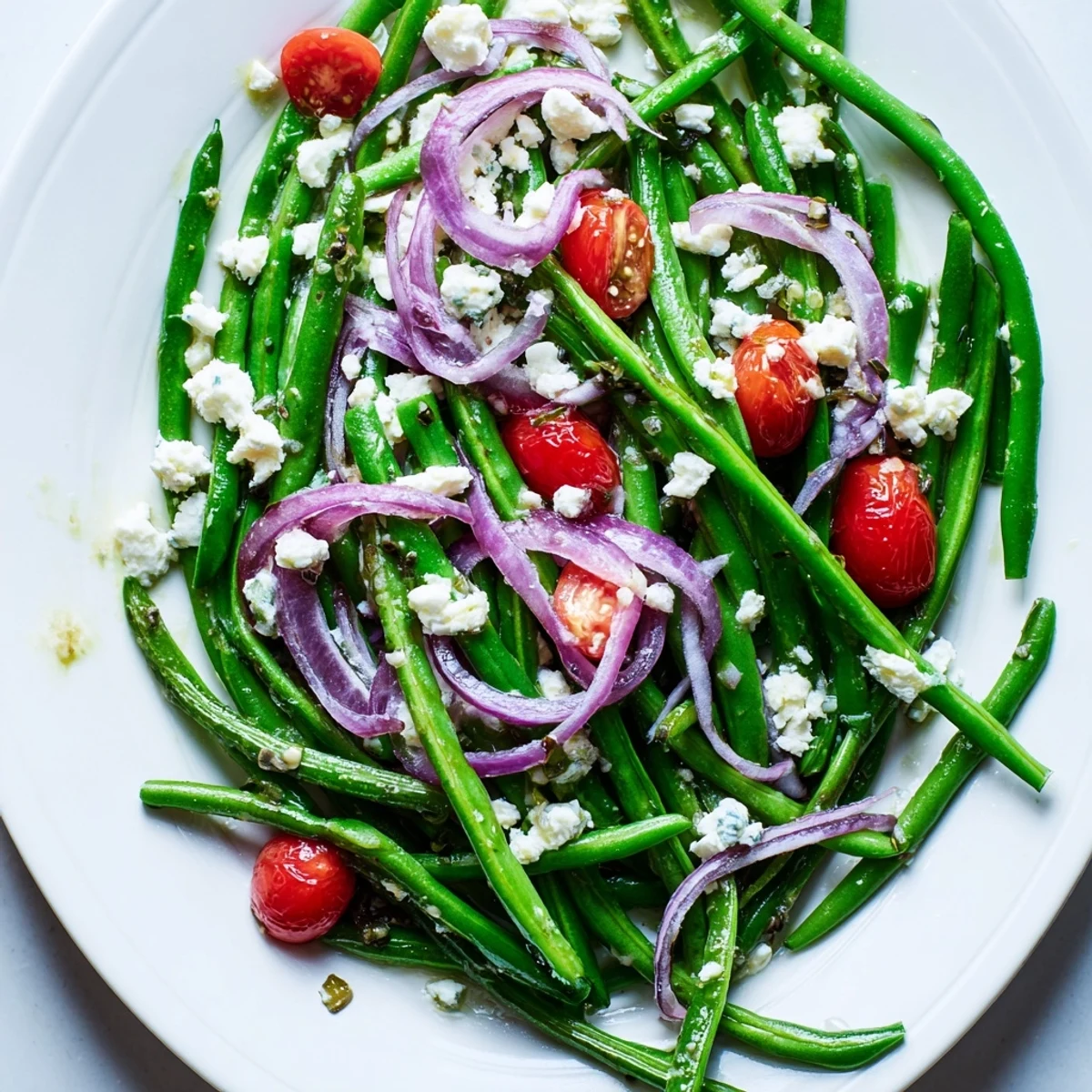 Vibrant Green Bean Salad with Feta featuring crisp beans, red onion, and parsley, served in a white bowl with a refreshing lemon dressing.