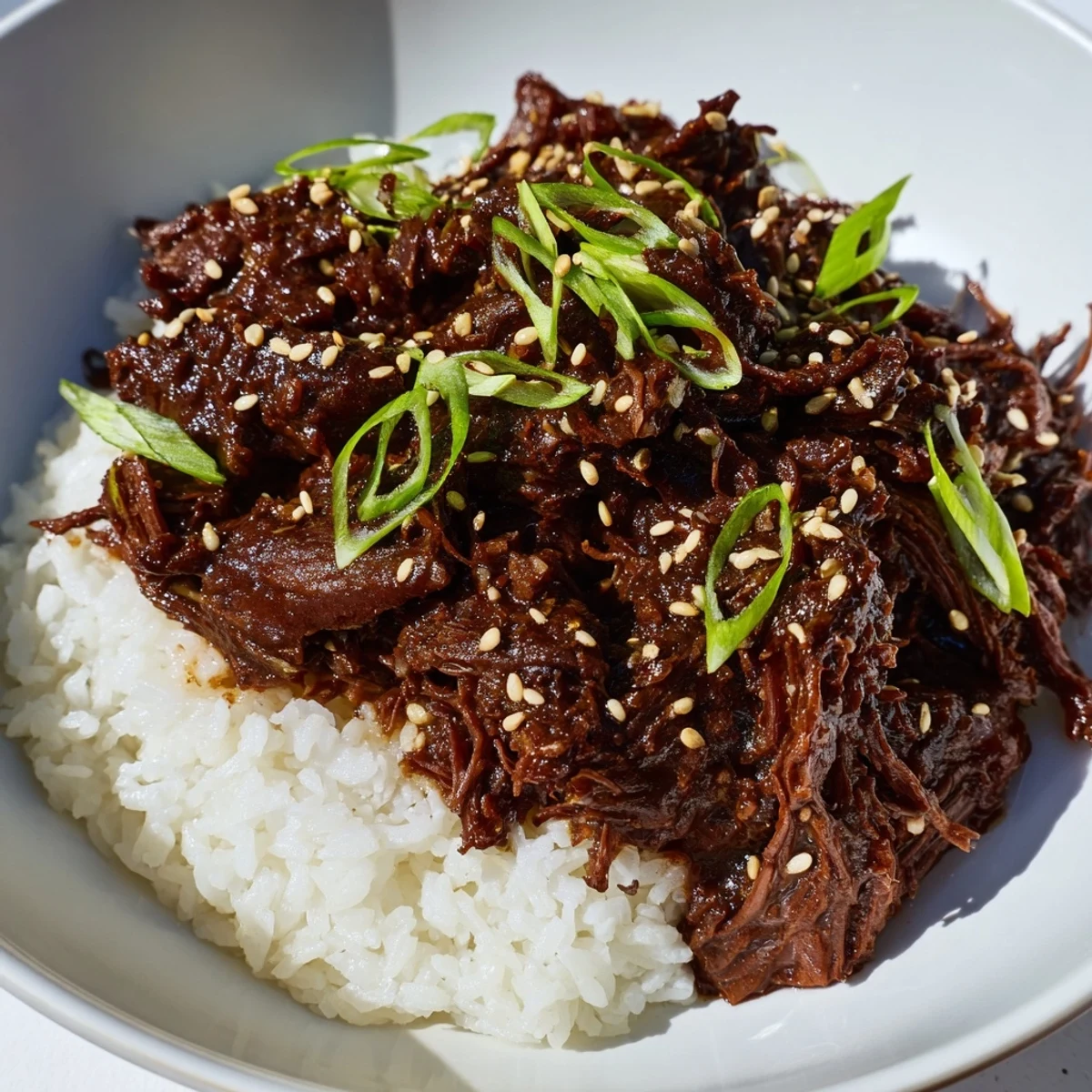 Fork-tender slow cooker Korean beef piled high with a rich gochujang sauce, paired with steamed rice for a comforting weeknight dinner.