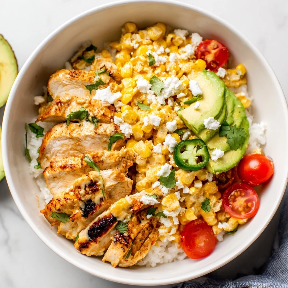 Colorful Street Corn Chicken Rice Bowl featuring juicy chicken, charred corn, cotija cheese, and fresh jalapeños on a bed of fluffy white rice.