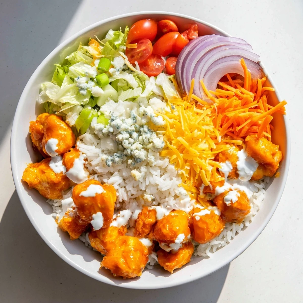 Fluffy rice topped with spicy Buffalo chicken, crisp romaine, shredded carrots, and creamy ranch drizzle.