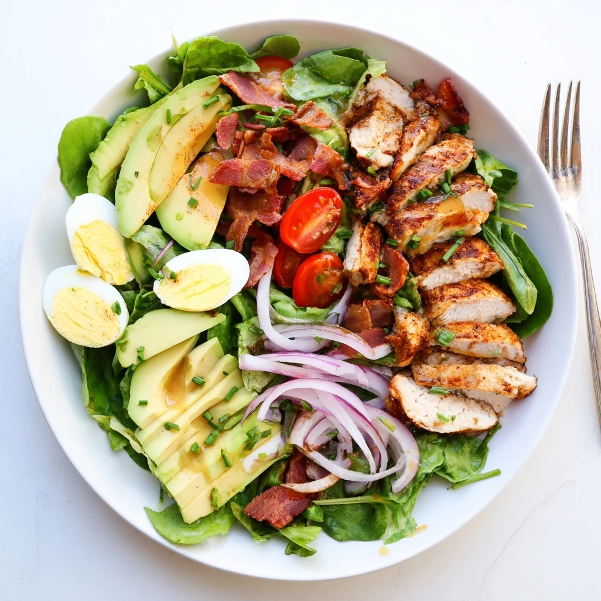 Vibrant Paleo Grilled Chicken Cobb Salad with sliced avocado, hard-boiled eggs, and colorful veggies on a platter ready to serve.