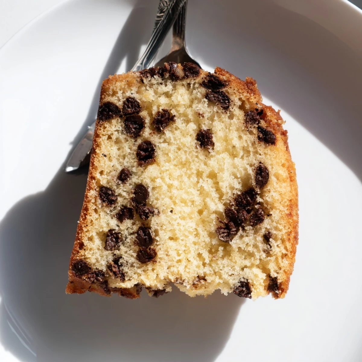 Rustic wooden board presentation of Chocolate Chip Cake with a scoop of vanilla ice cream melting on top.