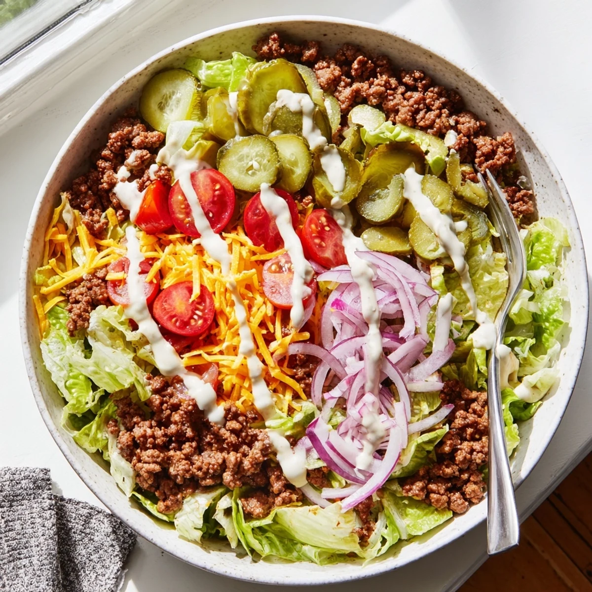Colorful Burger Bowls served in glass bowls, featuring juicy beef, shredded cheddar, and vibrant vegetables for a low-carb dinner.