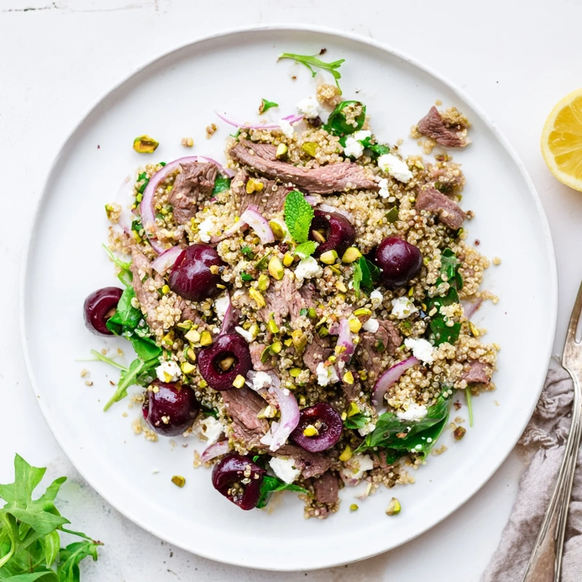 Protein-rich cherry quinoa salad with tender lamb slices, toasted nuts, and vibrant greens