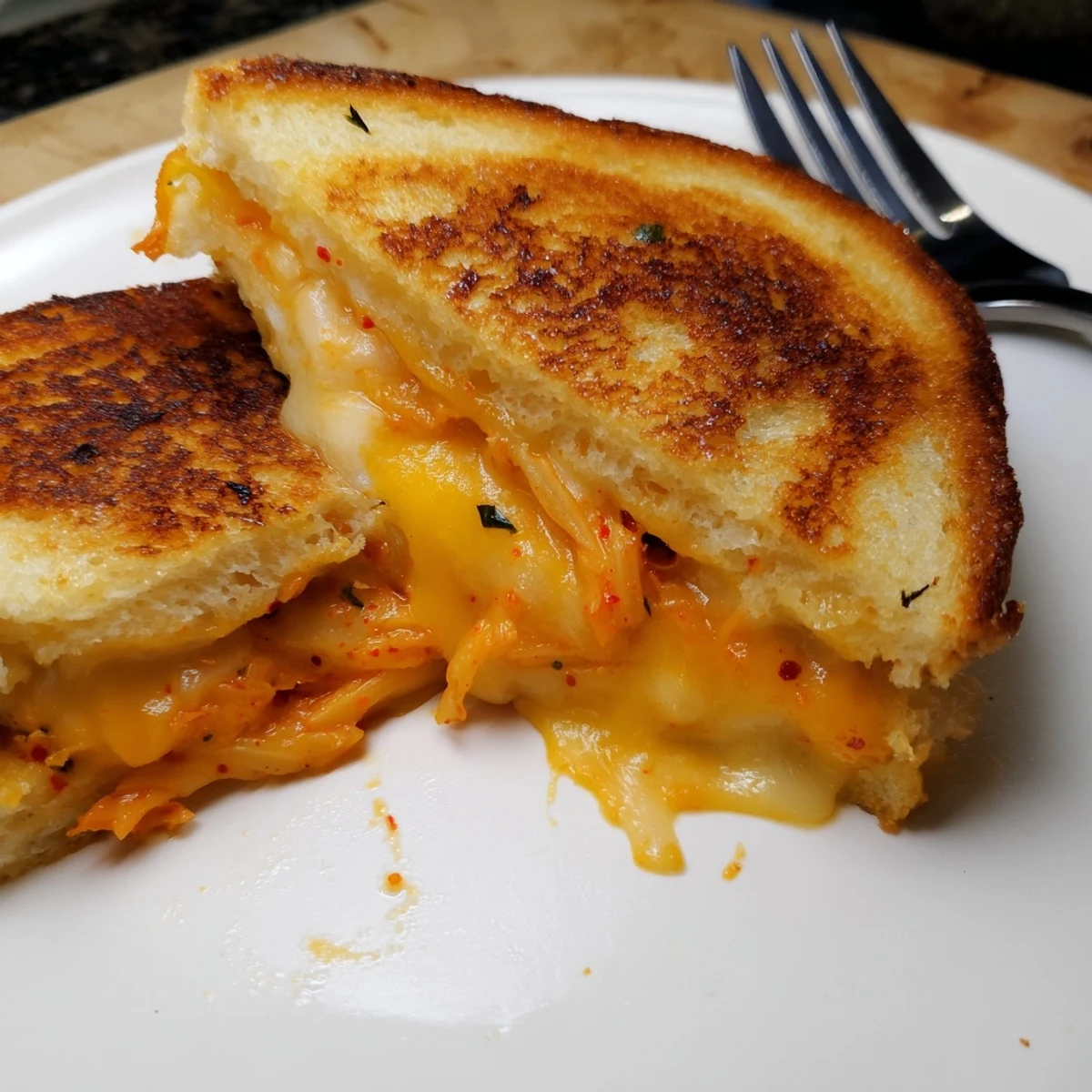 Korean-American fusion grilled cheese featuring spicy tangy kimchi layered between golden toasted bread with gooey cheese pull
