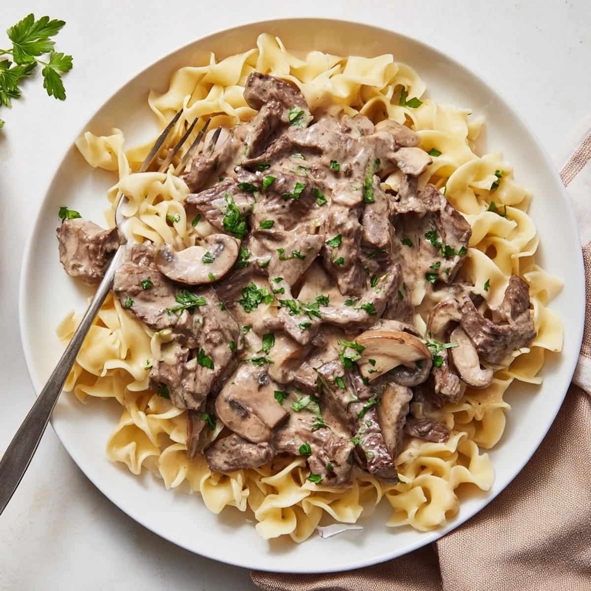 Creamy beef and mushroom stroganoff served over egg noodles with fresh parsley garnish