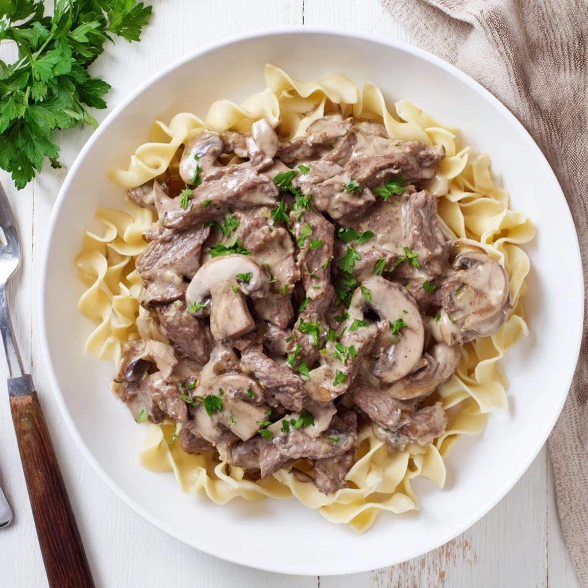 Homemade beef and mushroom stroganoff featuring savory steak and creamy sauce on egg noodles