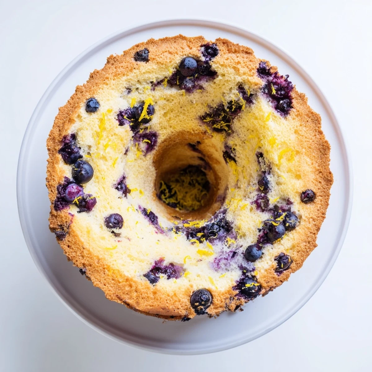 Golden slice of fluffy blueberry chiffon cake with fresh berries visible throughout the tender crumb