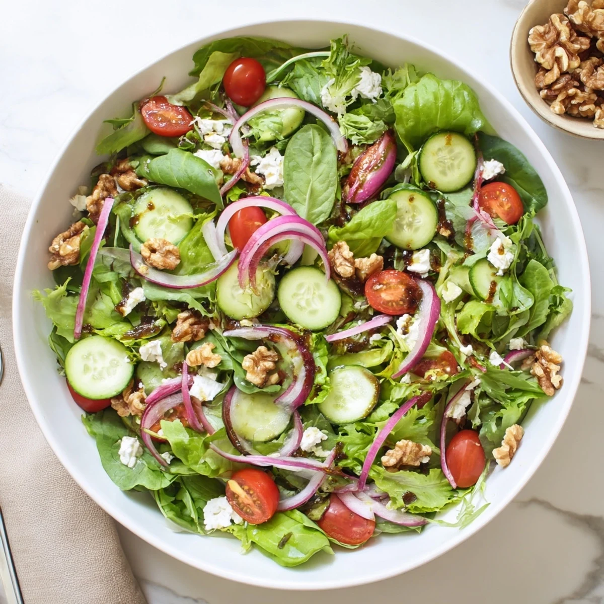 Light spring mix salad featuring honey balsamic vinaigrette coating tender lettuce, cherry tomatoes, and crunchy vegetables
