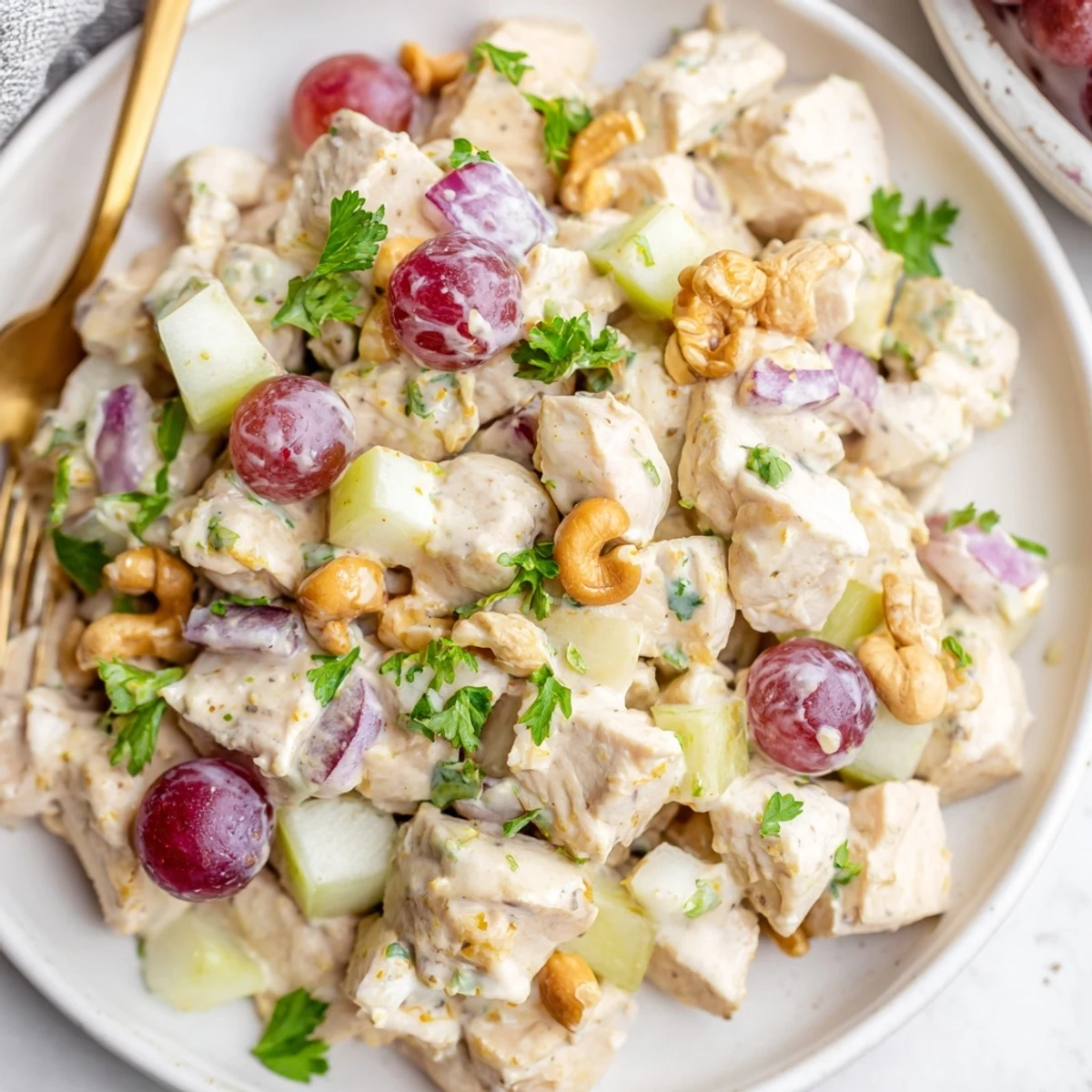 Vibrant chicken salad featuring tender meat, crisp celery, and sweet fruit in spiced yogurt-mayo blend