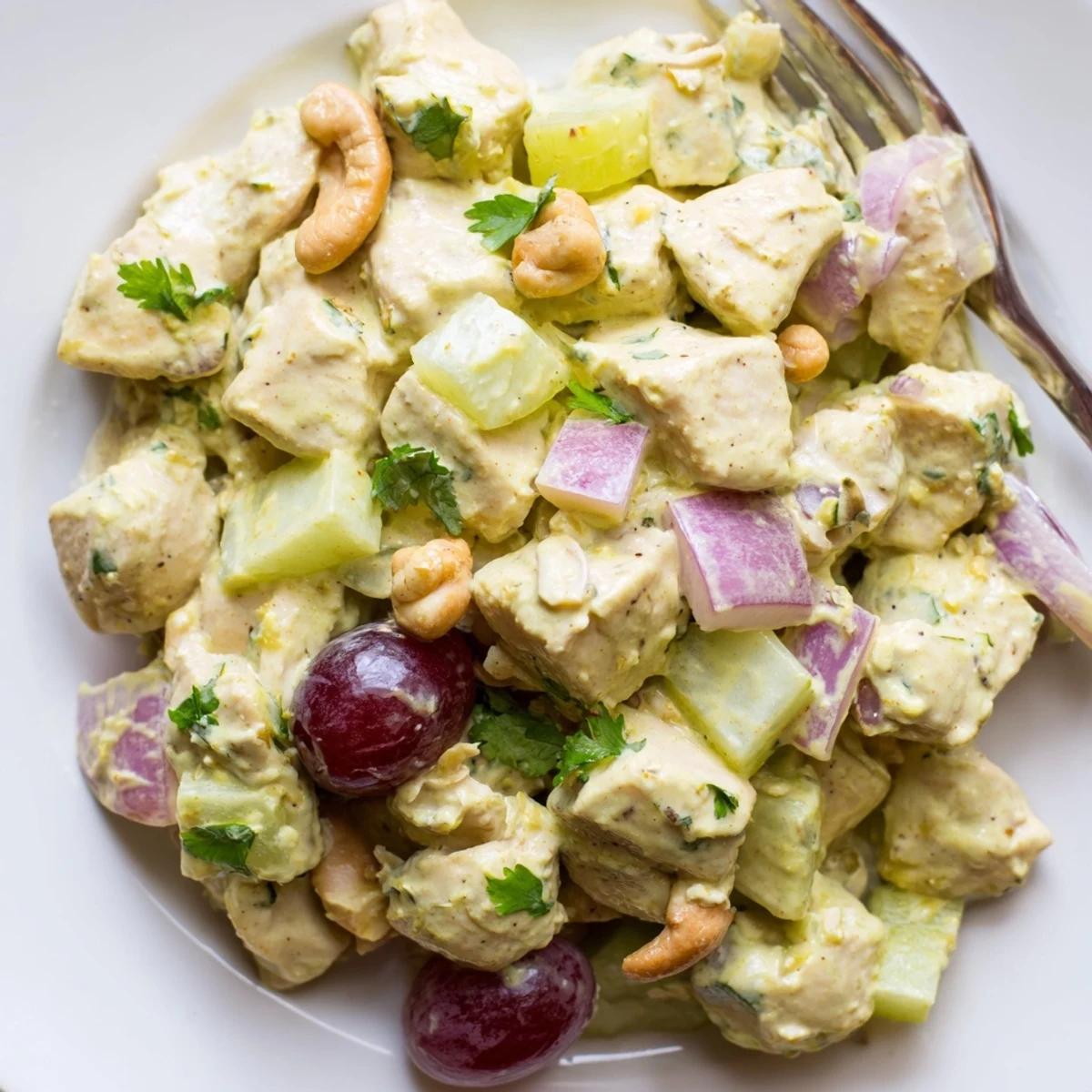 Creamy curry chicken salad bowl topped with fresh cilantro and crunchy cashews