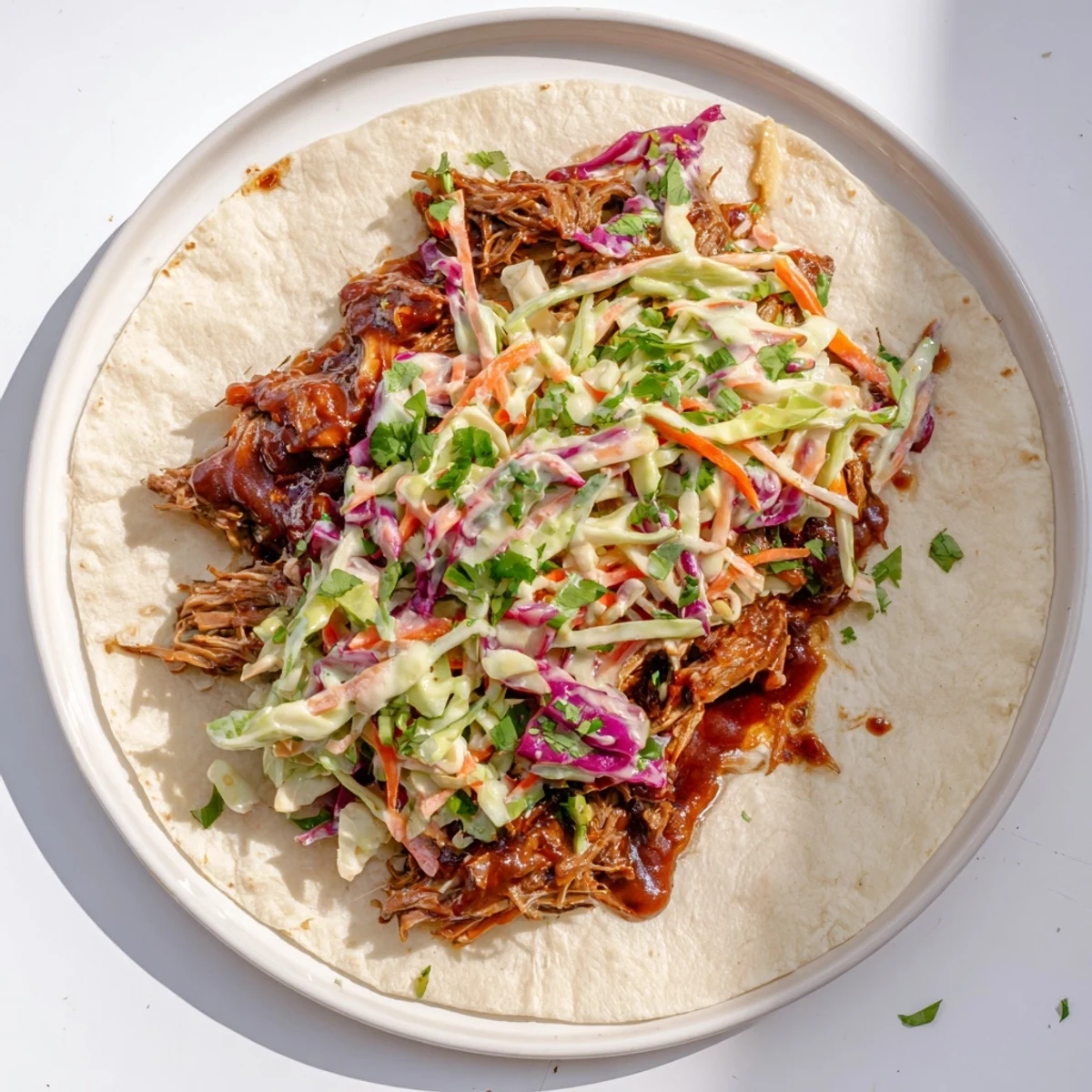 Close-up of sweet smoky BBQ beef wrap loaded with crisp shredded vegetable slaw