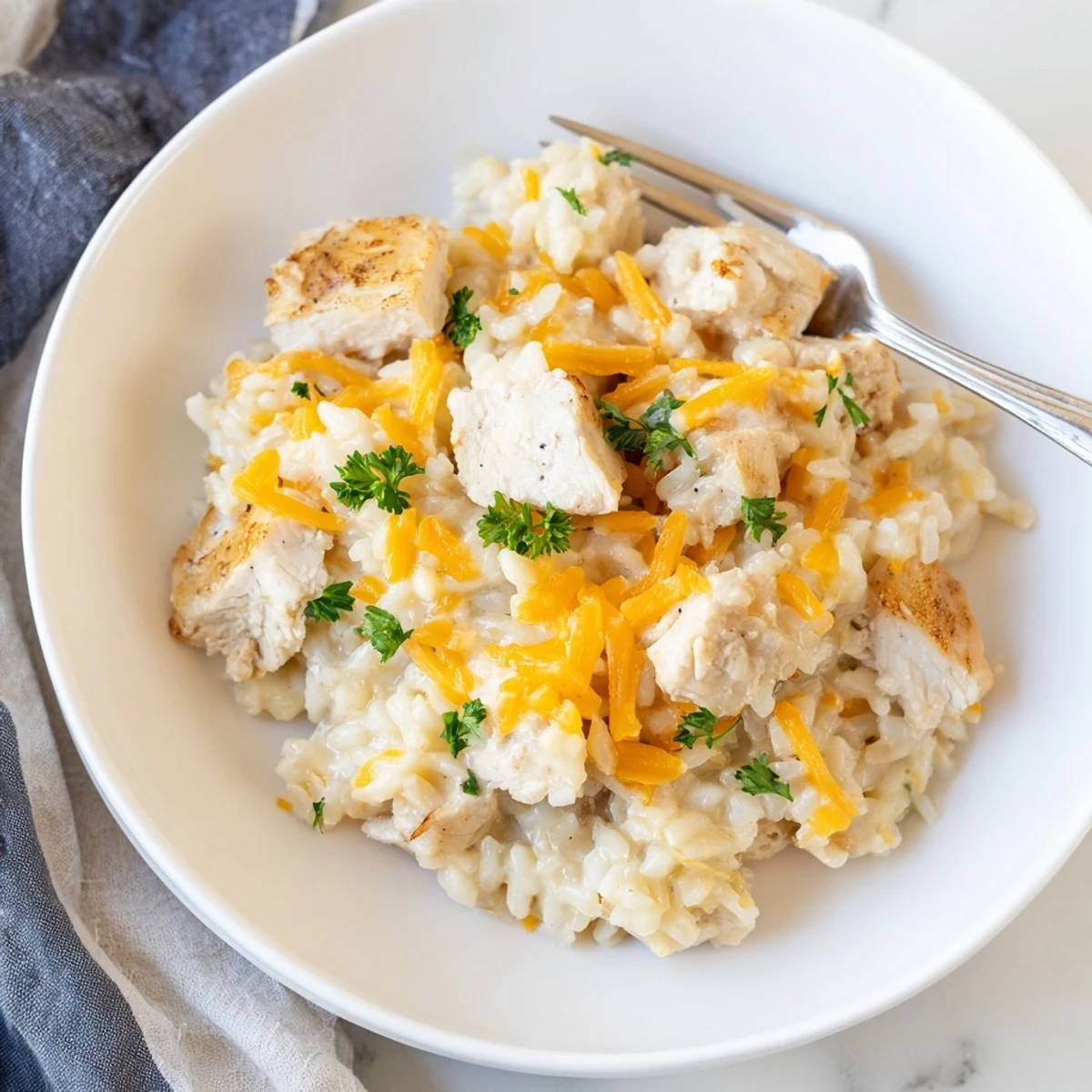 One-pan creamy smothered chicken and rice featuring tender meat nestled in melted cheese with aromatic herbs