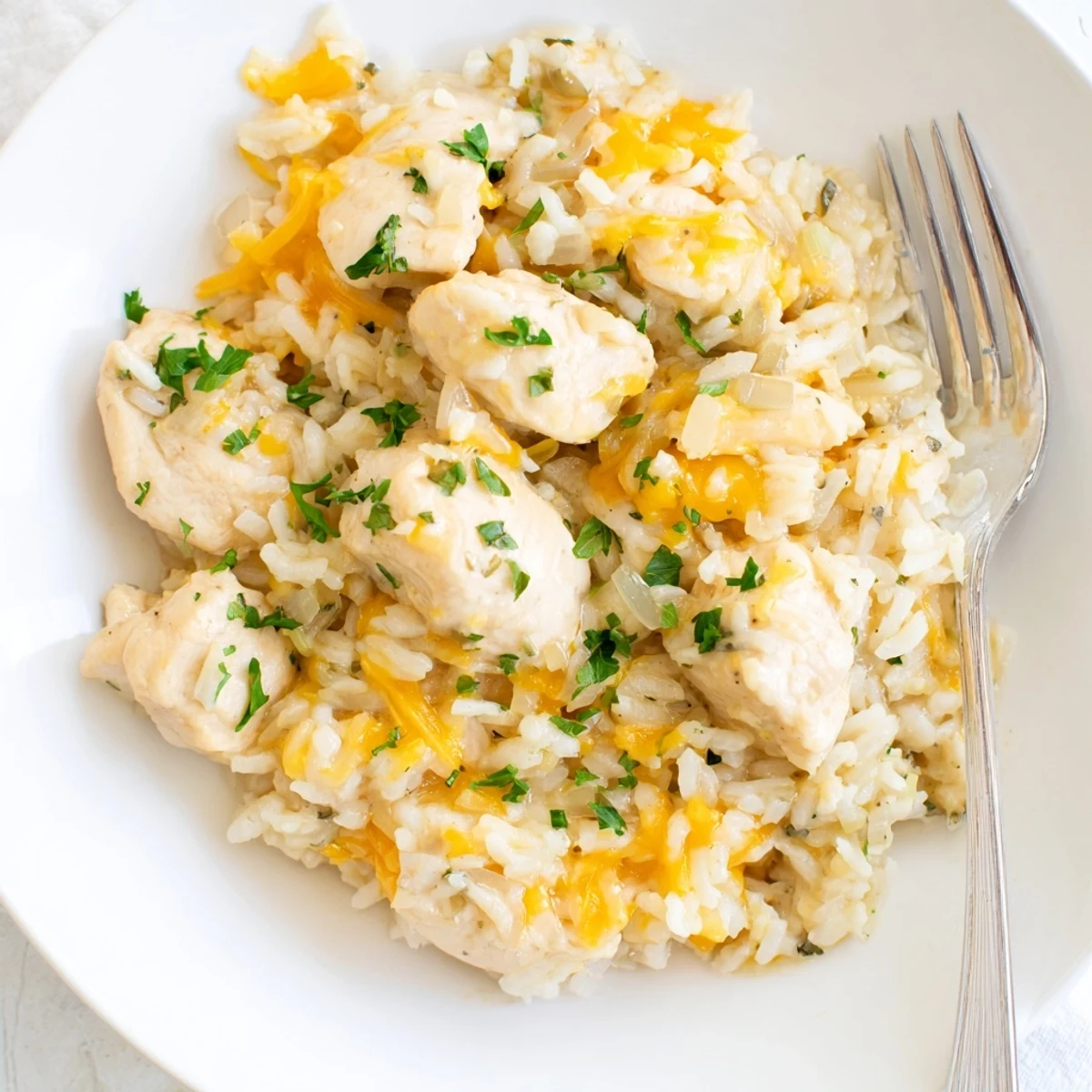 Comforting homestyle skillet meal of seared chicken and rice swimming in a velvety white cream sauce