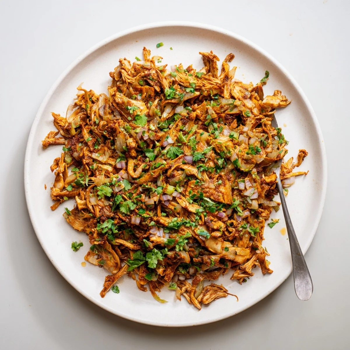 Golden brown vegan carnitas with shredded mushrooms cradled in warm corn tortillas