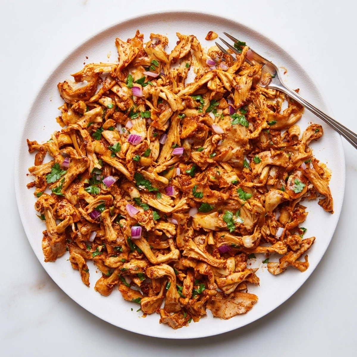 Savory spiced mushroom carnitas piled high with fresh cilantro and diced red onion