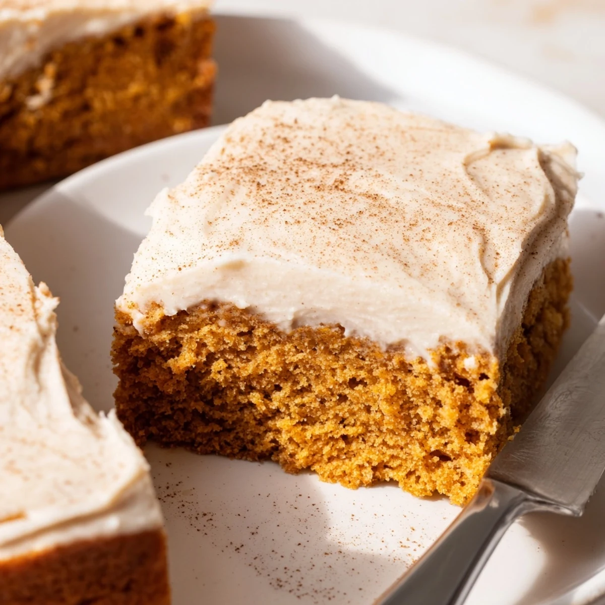 Thick swirls of tangy cream cheese frosting layered over moist golden pumpkin bars