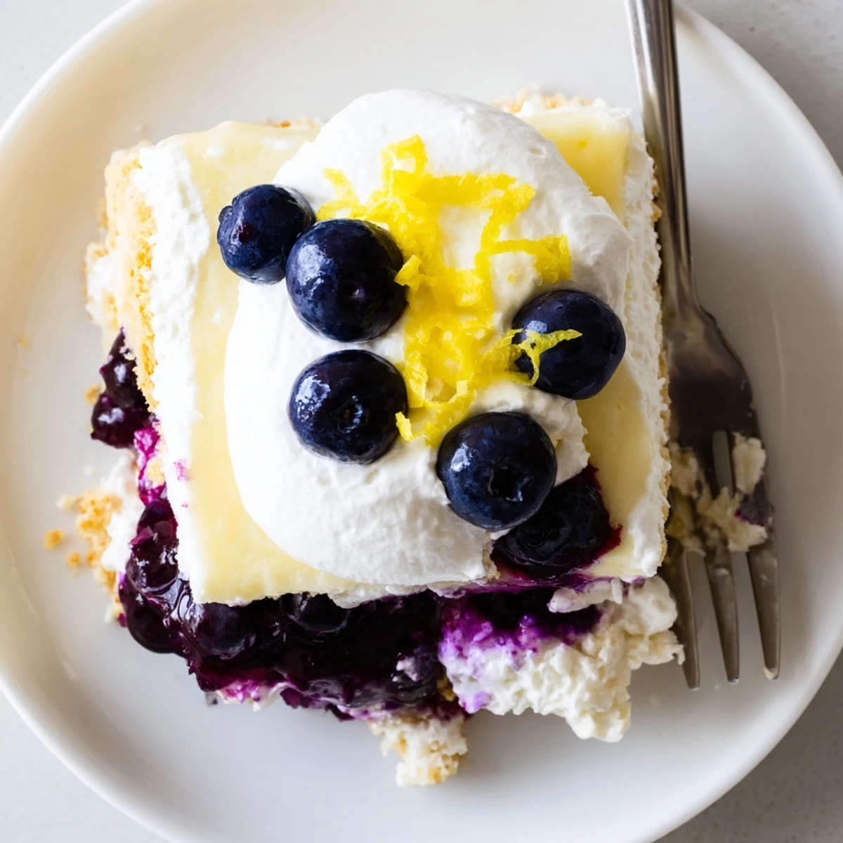 A square of lemon blueberry lasagna recipe with golden crust and bright fruit swirls.