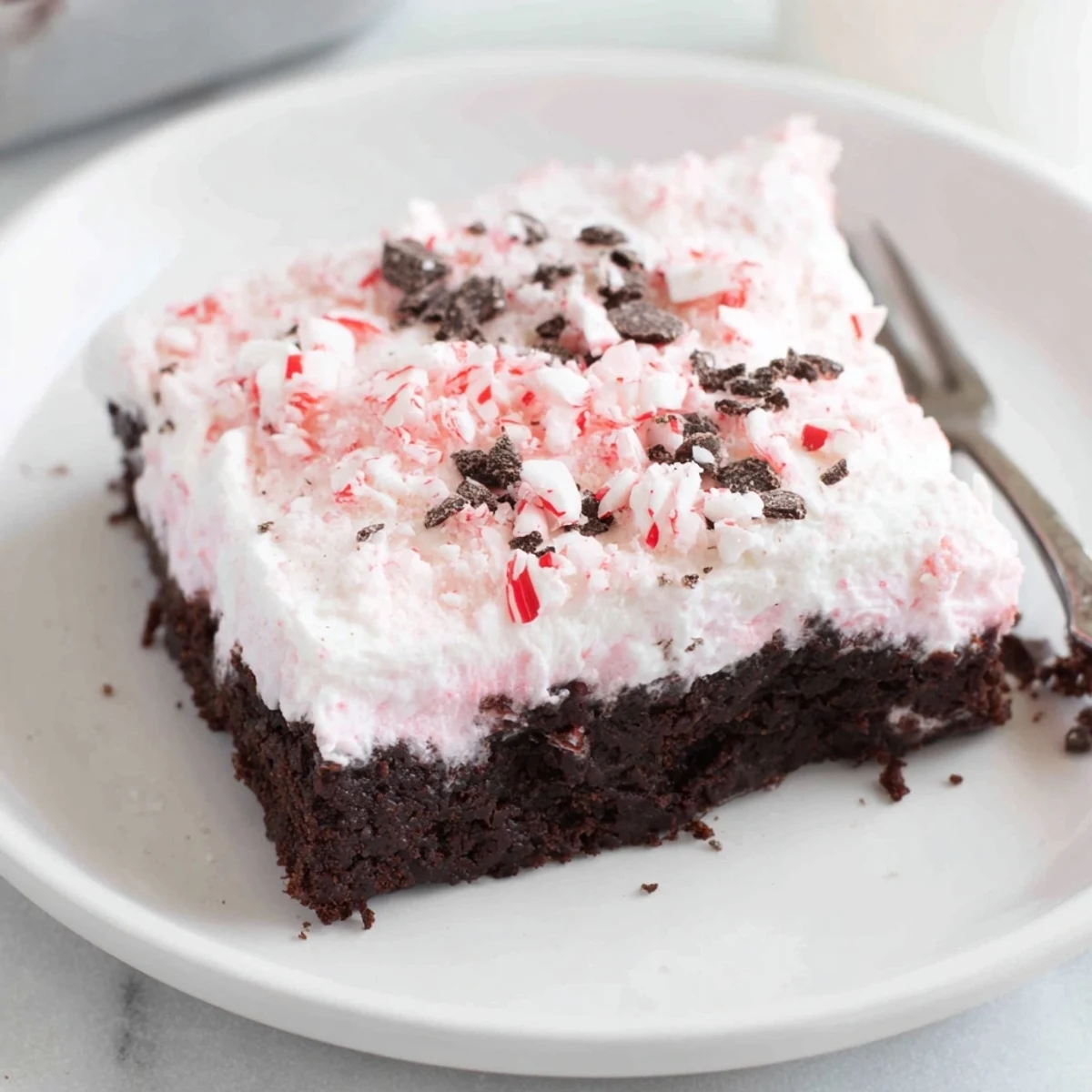 Peppermint Poke Cake garnished with chocolate shavings, ready for holiday serving