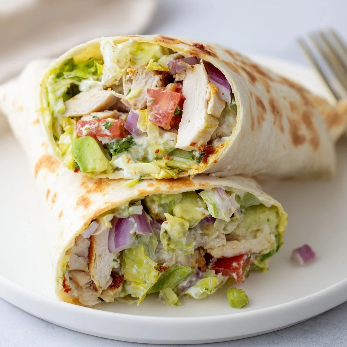 Handheld Chicken Avocado Ranch Burritos wrapped in warm tortillas, steam rising