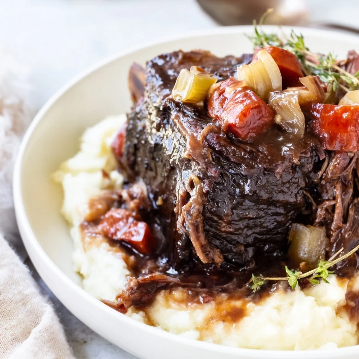 Slow Cooker Beef Short Ribs glazed in rich wine sauce, steaming over mashed potatoes