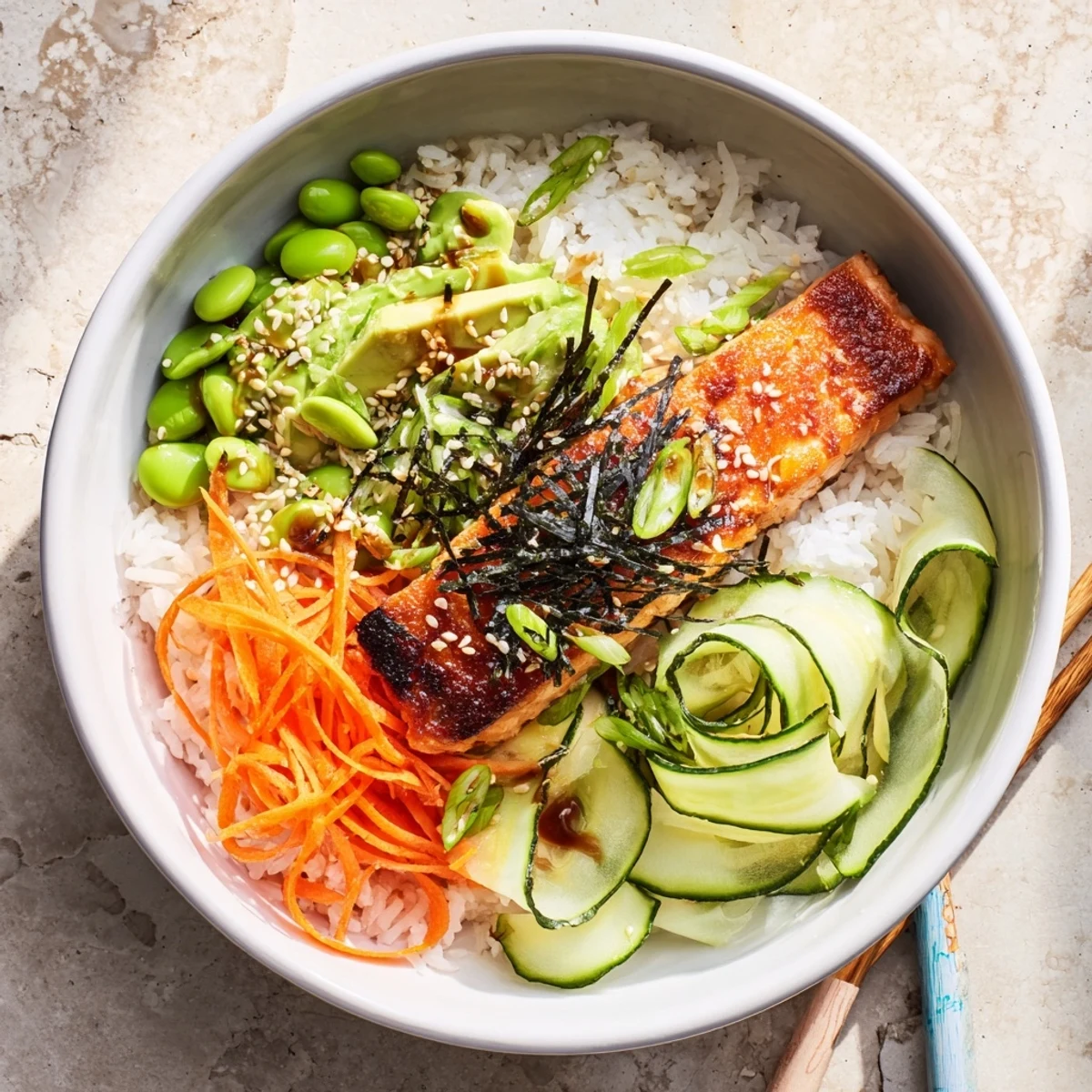 Savory crispy salmon and rice bowl drizzled with tangy sauce and topped with scallions and sesame seeds