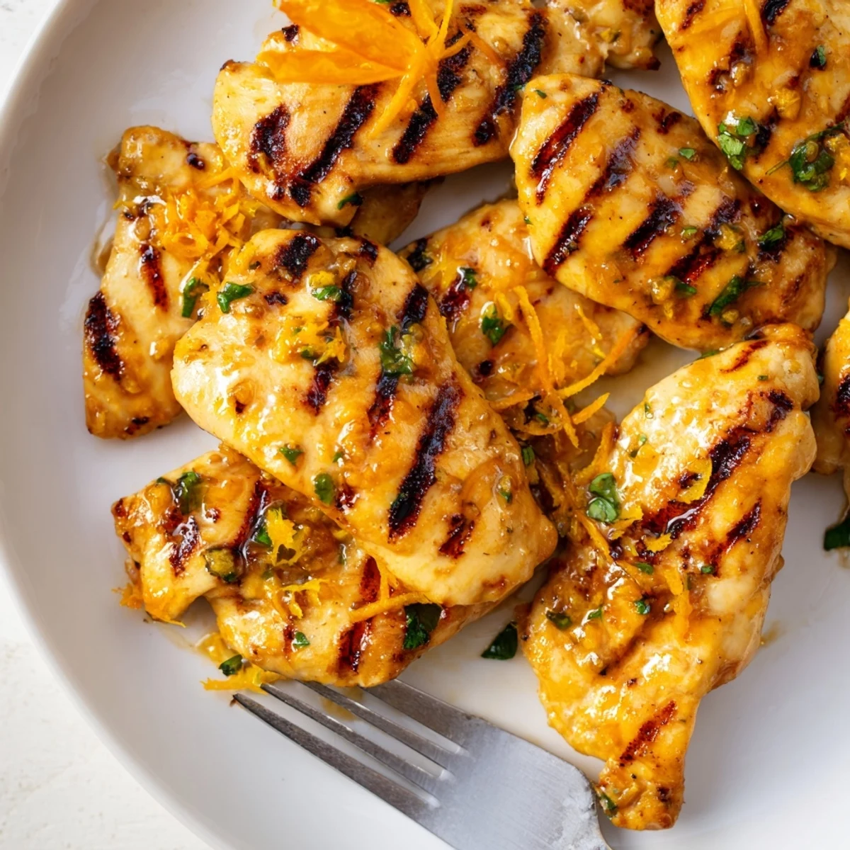 Tender Orange Dijon grilled chicken with honey mustard glaze served alongside fresh orange wedges