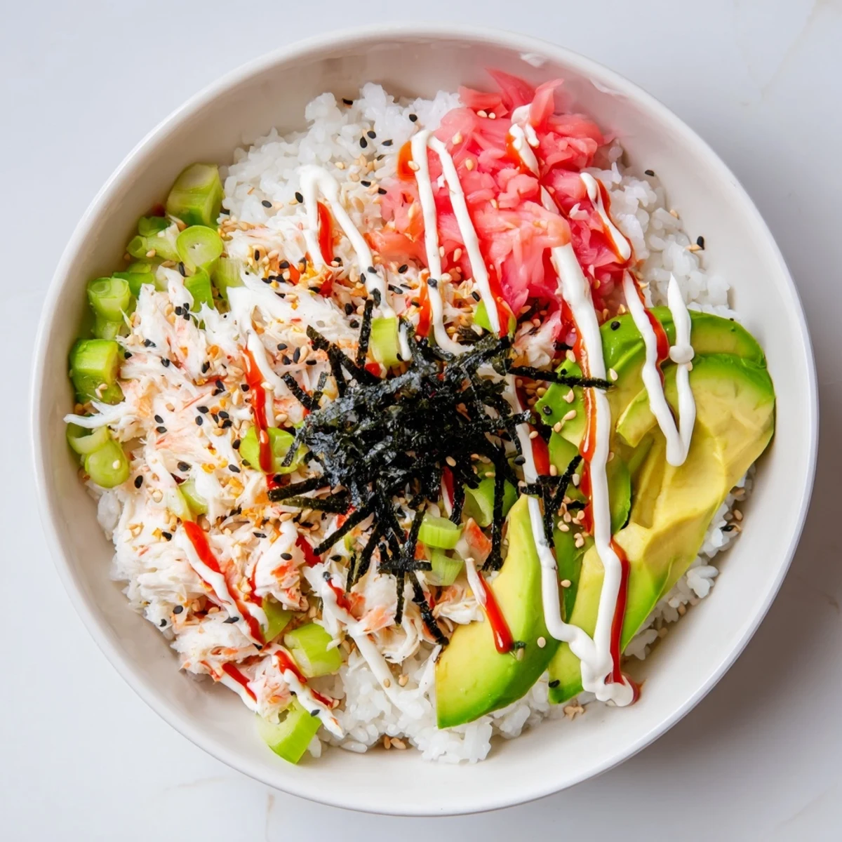 Homemade California Roll bowl arranged with shredded crab, diced cucumber and sesame seed garnish