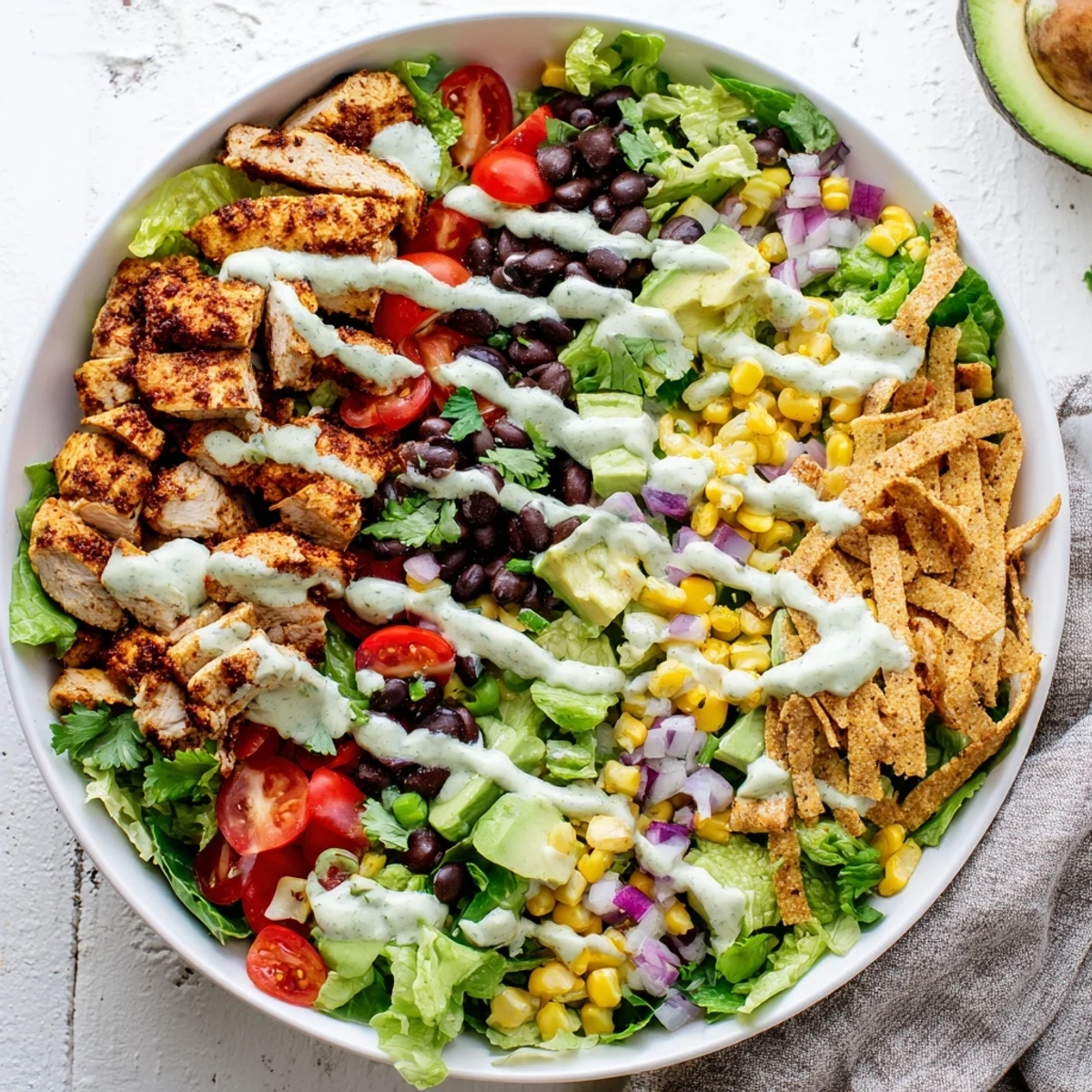 Colorful Southwestern chicken salad with grilled spiced chicken, fresh avocado, black beans, and crisp vegetables in a large serving bowl.