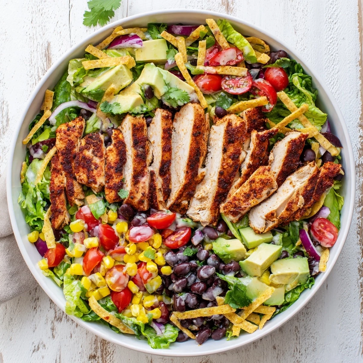 Hearty Southwestern chicken salad featuring tender spice-rubbed chicken, romaine, red bell peppers, and tortilla strips for a satisfying meal.