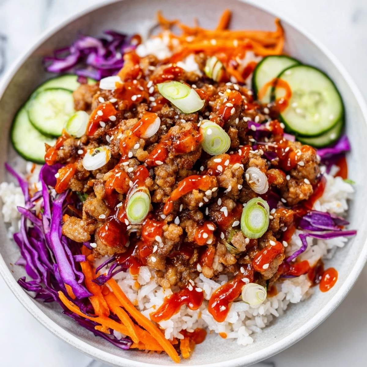 Creamy orange Bang Bang sauce cascades over seasoned ground turkey rice bowls with fresh slaw.