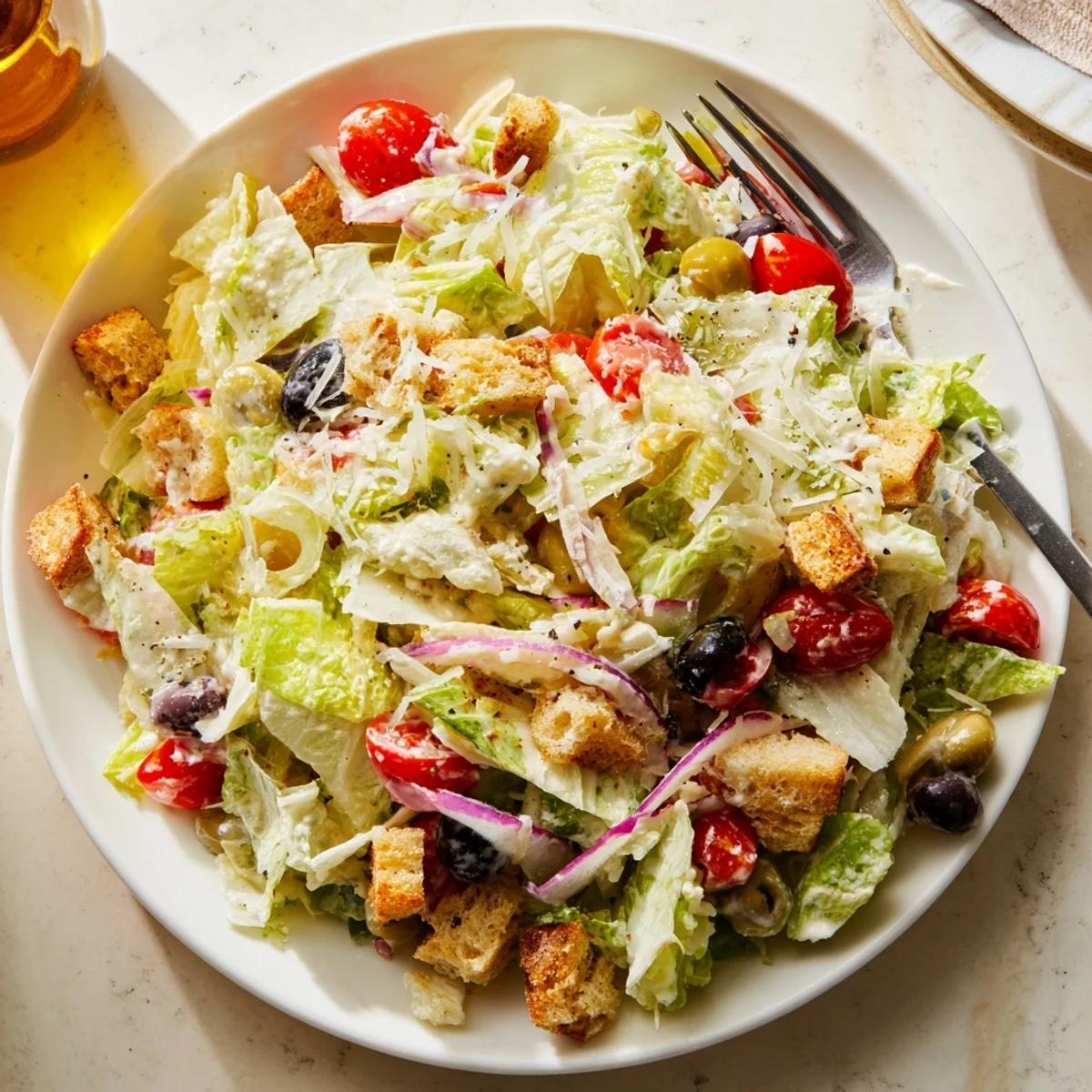 Fresh Olive Garden Salad drizzled with tangy dressing served on a white plate